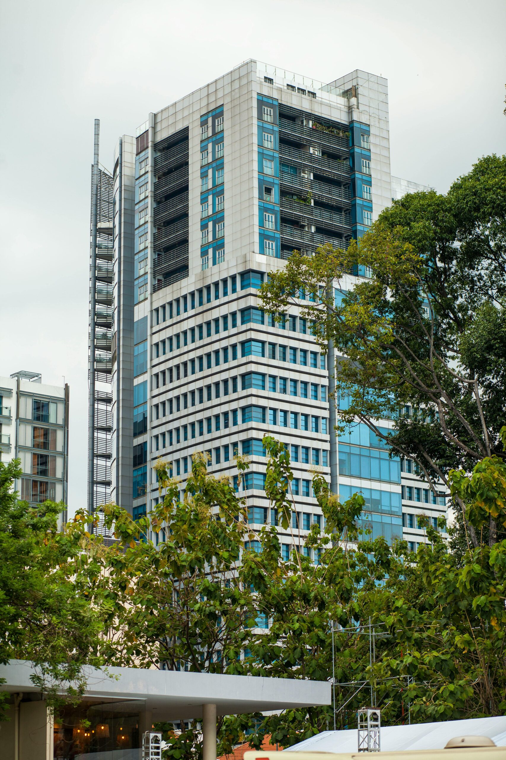 High-rise office building surrounded by lush green trees showcasing urban architecture and nature.